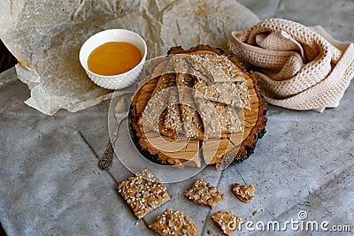 Healthy and nutritious diet bread with sesame and sunflower seeds on a thin crunchy malt base. Near natural bee honey and a wooden Stock Photo