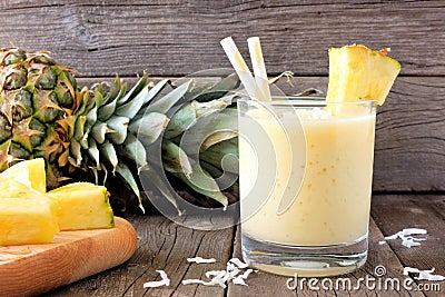 Healthy pineapple smoothie, scene against wood Stock Photo