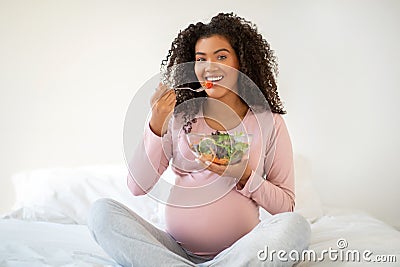 Healthy Pregnancy Nutrition. Cheerful Black Pregnant Woman Eating Fresh Vegetable Salad Stock Photo