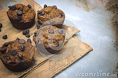 Healthy pumpkin chocolate chip muffins with golden napkin on baking sheet Stock Photo