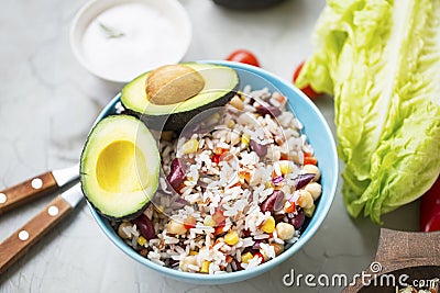 Healthy rice salad with vegetables and avocado, fresh organic vegan salad with fresh ingredients, vegan meal Stock Photo