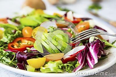 Healthy salad with bio organic vegetables, green vegan meal with avocado, pepper, radish, tomatoes, lettuce, cabbage, spring Stock Photo