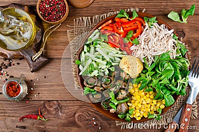 Healthy salad bowl with chicken, mushrooms, corn, cucumbers, sweet pepper and mix salad Stock Photo