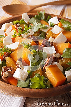 Healthy salad with persimmon, arugula and cheese macro vertical Stock Photo