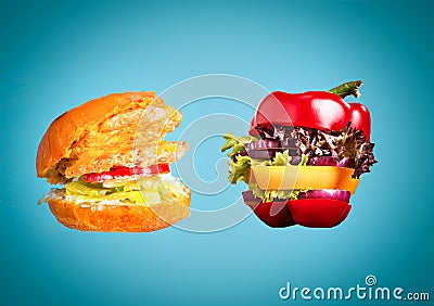 The healthy sandwich with fresh pepper, onion, salad lettuce and unhealthy harmful hamburger Stock Photo