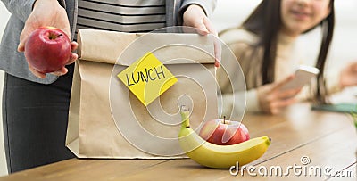 Healthy School Lunch. Mother Packing Food For Daughter Stock Photo