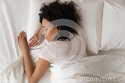 Healthy serene african girl sleeping in comfortable bed, top view Stock Photo