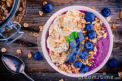 Healthy smoothie bowl with granola, banana and fresh blueberries Stock Photo