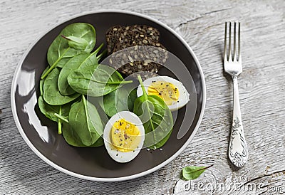 Healthy snack - fresh spinach and an egg on a brown plate Stock Photo