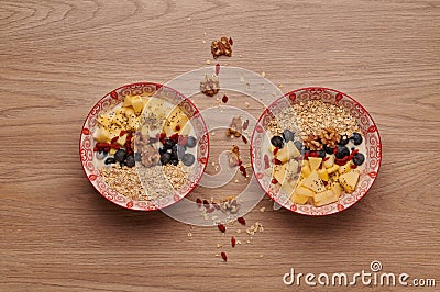 Healthy snacks in bowl: yoghurt, oat flakes, fruit, chia and goji seeds Stock Photo