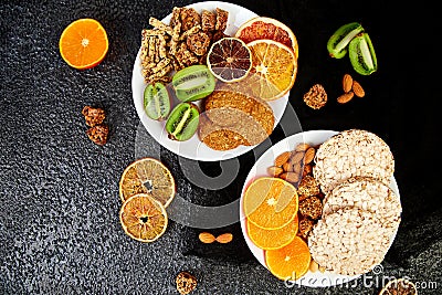 Healthy snacks - variety oat granola bar, rice crips, almond, kiwi, dried orange Stock Photo