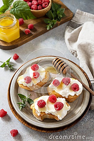 Healthy summer breakfast with sweet sandwiches with ricotta, raspberries and honey on a stone table Stock Photo