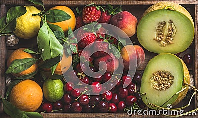 Healthy summer fruit variety. Melon, sweet cherries, peach, strawberry, orange and lemon on wooden tray background Stock Photo