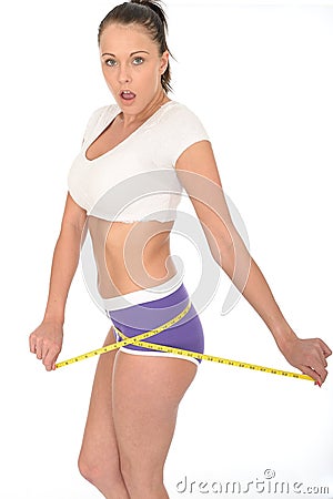 Healthy Surprised Fit Young Woman Checking Her Weight Loss With a Tape Measure Stock Photo