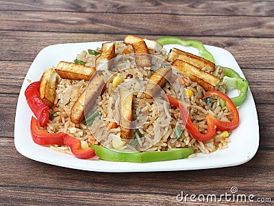 Healthy and tasty Paneer fried rice made of rice, mixed veggies and paneer, served in bowl over a rustic wooden background, Indo Stock Photo
