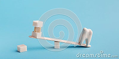 Healthy tooth and sugar balancing on seesaw swing Stock Photo