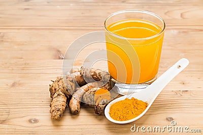 Healthy turmeric roots drinks in a transparent glass on wooden s Stock Photo