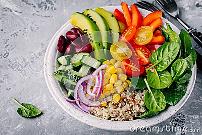 Healthy vegan lunch Buddha bowl. Avocado, quinoa, tomato, cucumber, red beans, spinach, red onion and red paprika vegetables salad Stock Photo