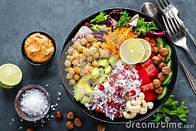 Healthy vegetarian Buddha bowl with fresh vegetable salad, rice, chickpea, avocado, sweet pepper, cucumber, carrot, pomegranate an Stock Photo