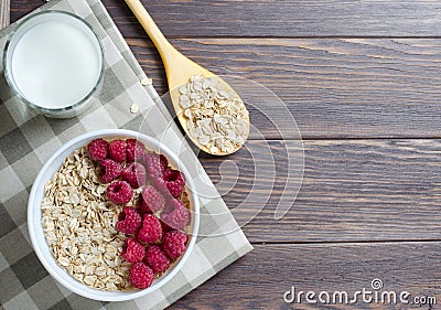 Healthy vegetarian food. Oatmeal with raspberry. Wooden spoon with cereals. Brown wooden background. Copy space Stock Photo