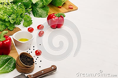 Healthy vegetarian ingredients for spring fresh green salad and kitchenware on white wood table, copy space. Stock Photo