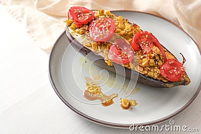 Healthy vegetarian low carb meal, baked eggplant with turmeric, ginger, onions, tomatoes and sesame seed on a plate on a white Stock Photo