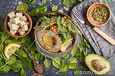 Healthy vegetarian salad with tofu, chickpea, avocado and sunflower seeds. Healthy vegan food concept. Dark background, top Stock Photo