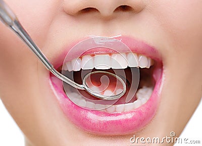 Healthy white woman's teeth and a dentist mouth mirror Stock Photo