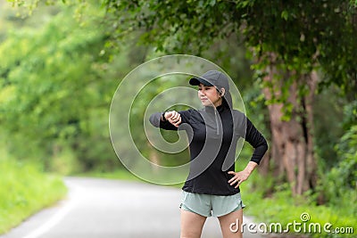 Healthy woman relax after cool down and looking smart watch for check timing run. Stock Photo