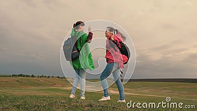 Healthy women tourists travel with backpacks in colorful raincoats. Slow motion. teamwork of travelers. Free girls Stock Photo