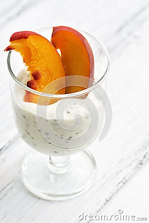 Healthy yogurt with peach and chia seeds on a white rustic table. Selective focus. Stock Photo