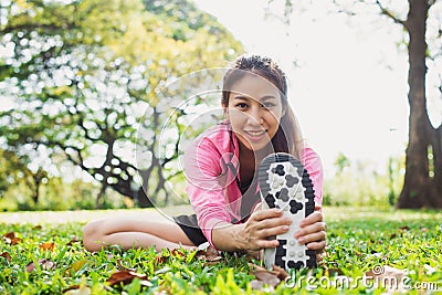 Healthy young asian woman exercising at park. Fit young woman doing training workout in morning. Stock Photo