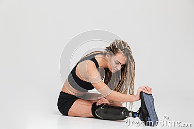 Healthy young disabled sportswoman make stretching exercises. Stock Photo