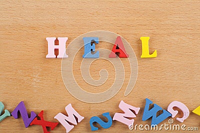 HEALword on wooden background composed from colorful abc alphabet block wooden letters, copy space for ad text. Learning english Stock Photo