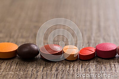 capsules on wooden table. Pills are making a line or path. Concept of way, course. Stock Photo