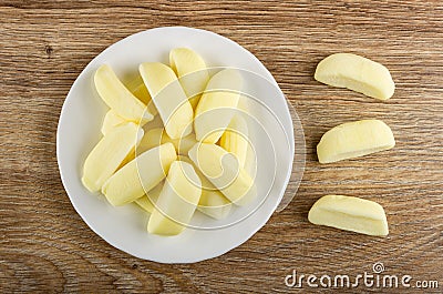 Heap of candies in shape of bananas in plate, candies on table. Top view Stock Photo