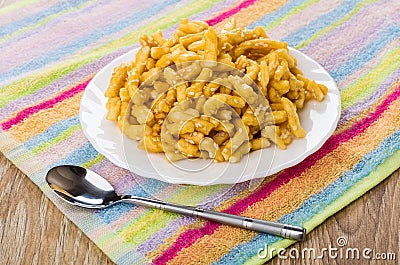 Chuck-chuck in plate, teaspoon on napkin on wooden table Stock Photo