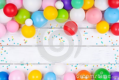 Heap of colorful balloons and confetti on white table top view. Festive or party background. Flat lay. Birthday greeting card Stock Photo