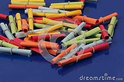 A heap of colorful tombola tickets are lying on a blue ground Stock Photo