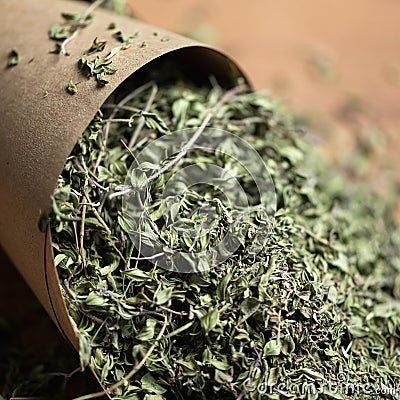 Heap of dry green tea leaves in paper packaging on blurred background. Antioxidant, healing power of nature. Close up Stock Photo