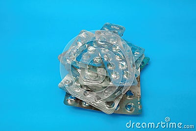 Heap empty blister packs without pills on blue background. Medical and healthcare concept Stock Photo