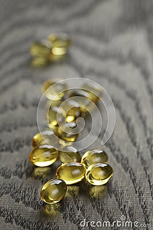 Heap of fish oil omega capsules on wooden table Stock Photo