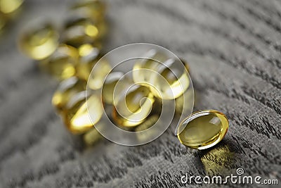 Heap of fish oil omega capsules on wooden table Stock Photo