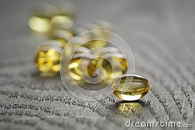 Heap of fish oil omega capsules on wooden table Stock Photo