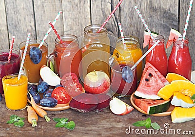 Heap of fresh fruits and fresh prepared cocktails of different colors on a wooden table.Rustic style Stock Photo