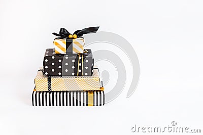 A heap of gift boxes in various black, white and golden designs arranged like layers of a birthday cake. A concept of Christmas, N Stock Photo