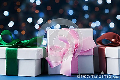 Heap of gifts boxes or presents against blue bokeh background. Holiday christmas greeting card. Stock Photo