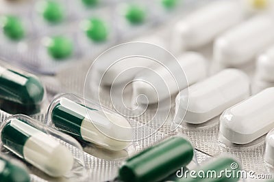 Heap of medical pills in white, green and other colors. Herbal medical pills. Pills in plastic package. Concept of healthcare and Stock Photo