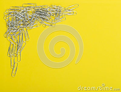 Heap of note paper clips on yellow background top view Stock Photo