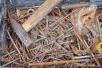 Heap of old rusty nails and screws on bottom of can with hammer Stock Photo
